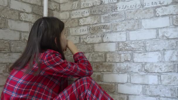 Girl in pajamas doing math homework on wallpaper — Stock Video