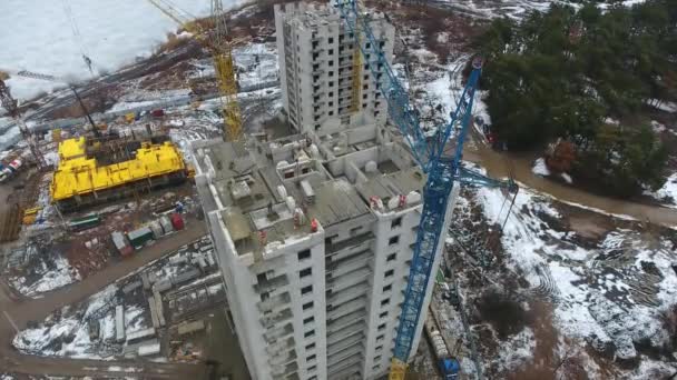 Luchtfoto van kraan lossen betonnen blokken op de top van het gebouw — Stockvideo