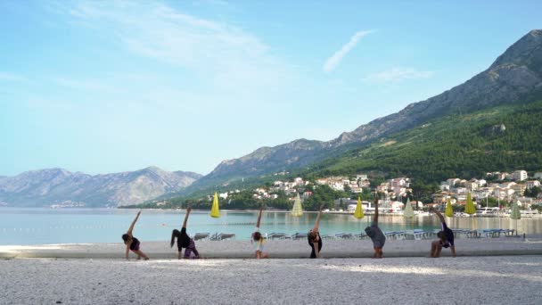 Gente haciendo yoga junto al mar — Vídeo de stock