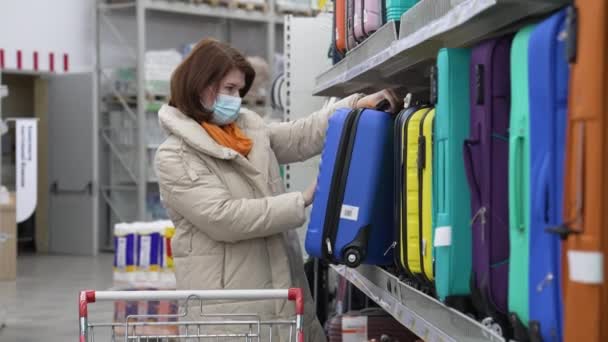 Mulher mascarada a olhar para a mala no supermercado — Vídeo de Stock
