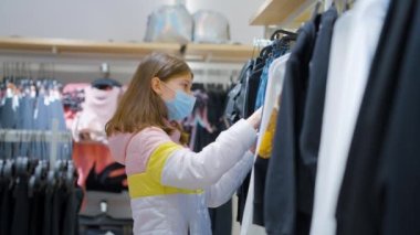 Salgın sırasında süpermarkette kıyafet seçen bir kız