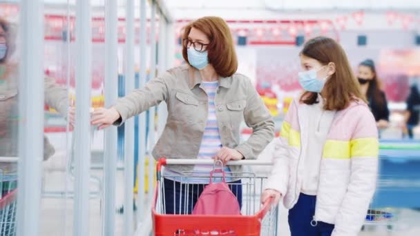 Familie doet boodschappen in de voedselwinkel tijdens de pandemie — Stockvideo