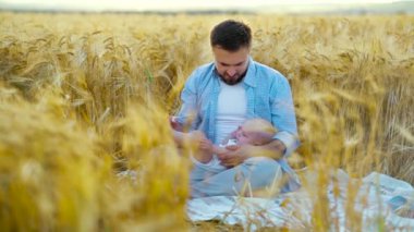 Babacığın tarlada bebeği kucaklayıp öpmesi