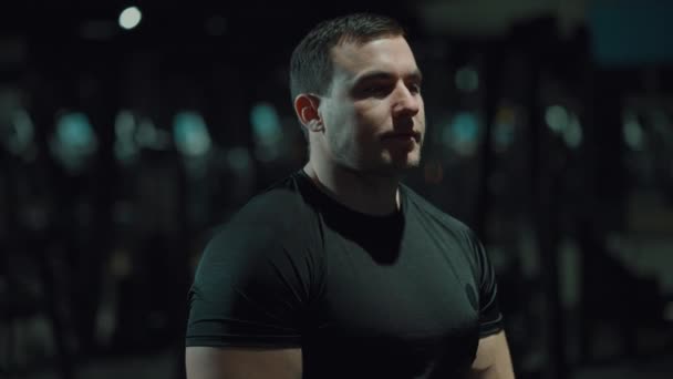 Hombre fuerte posando en gimnasio oscuro — Vídeos de Stock