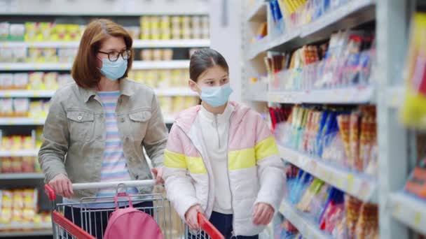 Mãe e filha comprando chocolate na loja durante a pandemia — Vídeo de Stock