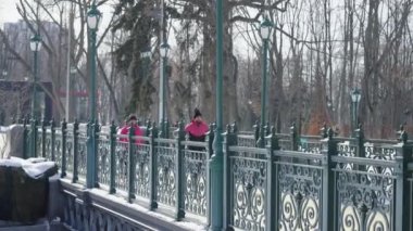 Kışın köprüde koşan koşucular
