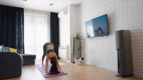 Donna che guarda video e pratica yoga a casa — Video Stock