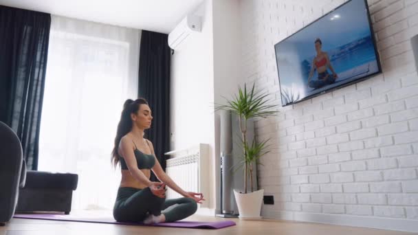 Donna che medita in posizione yoga a casa — Video Stock