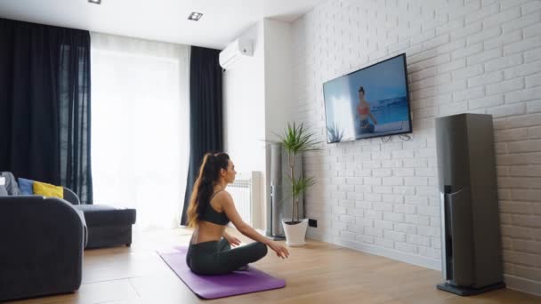 Mulher assistindo aula de ioga online e meditando em casa — Vídeo de Stock