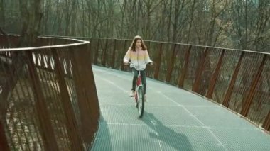 Yuvarlak köprüde bisiklet süren kız