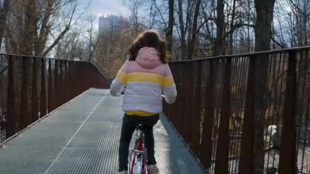 Fille vélo sur le pont dans le parc — Video