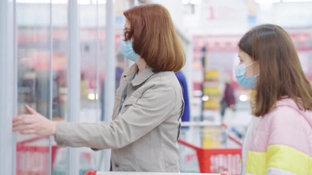 Moeder en dochter kopen worstjes in supermarkt tijdens pandemie — Stockvideo