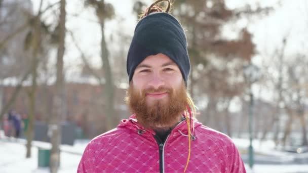 Hombre barbudo riendo de la cámara en el parque de invierno — Vídeos de Stock