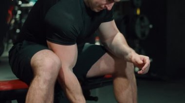Adam dambılla pazı egzersizi yapıyor.