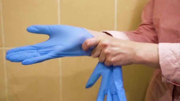 Hände der Frau ziehen Latex-Handschuhe an — Stockvideo