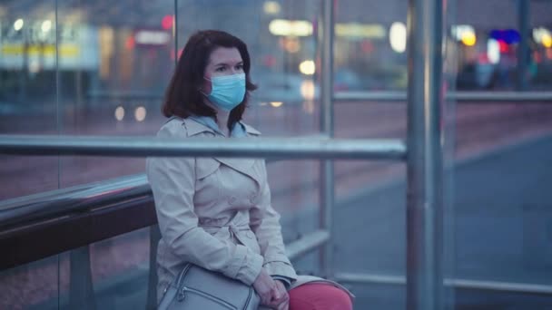 Woman in mask sitting at bus stop — Stock Video