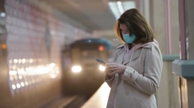 Metroda telefonu olan bir kadın.