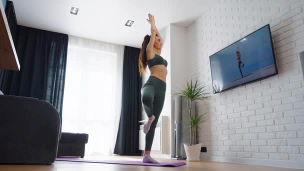 Женщина-йога балансирует на одной ноге — стоковое видео