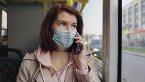 Pasajero en máscara hablando por teléfono en autobús — Vídeos de Stock