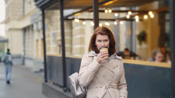 Woman walking in city and drinking coffee — Stock Video