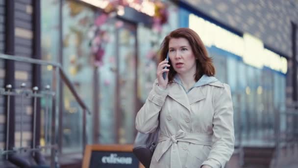 Mujer de negocios caminando por la ciudad y hablando por teléfono — Vídeos de Stock