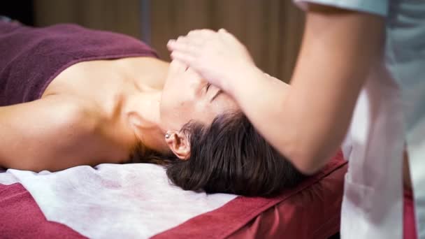 Vrouw het krijgen van gezicht massage in wellness spa — Stockvideo