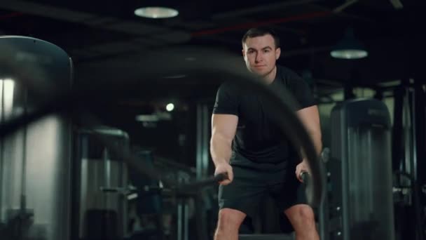 Hombre haciendo ejercicio con cuerdas de batalla en el gimnasio — Vídeos de Stock