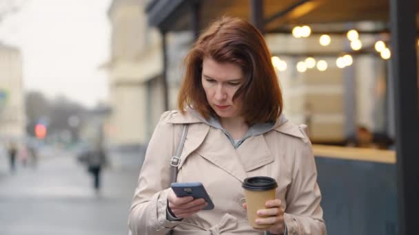 Mujer llamando por teléfono mientras camina en la ciudad — Vídeos de Stock