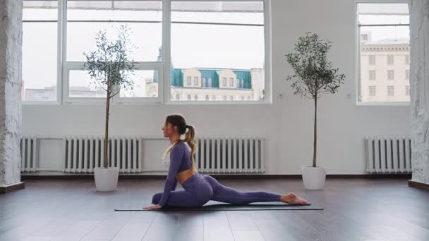 Yogi-Frau sitzt in Ardha Kapotasana-Pose — Stockvideo