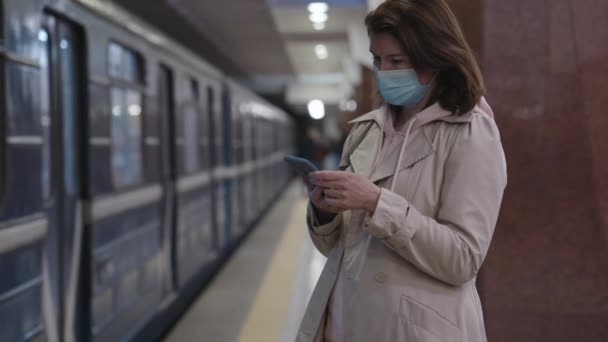 Mujer en la máscara de control de teléfono inteligente en metro — Vídeo de stock