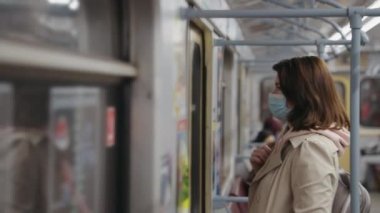 Metro treninde maske takan bir kadın.