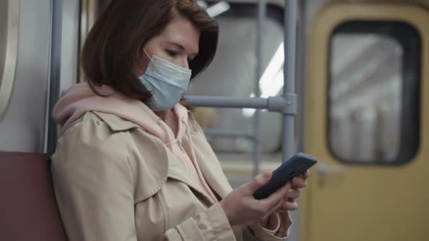 스마트폰을 사용하여 마스크를 쓴 지하철 승객 — 비디오