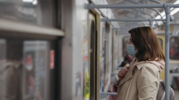 Woman in mask commuting in subway train — Stock Video