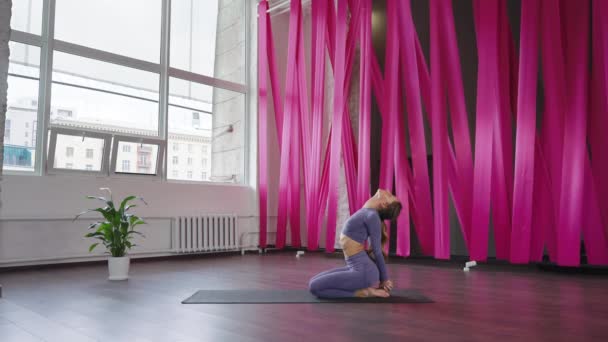 Жінка - йоги, яка розтягує асан у студії. — стокове відео