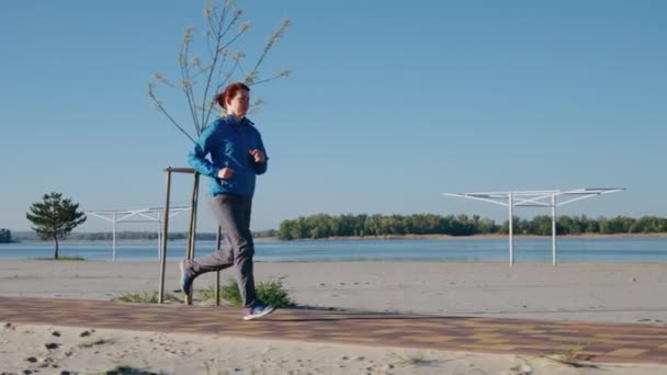 아침에 해변을 따라 달리는 조깅하는 사람 — 비디오