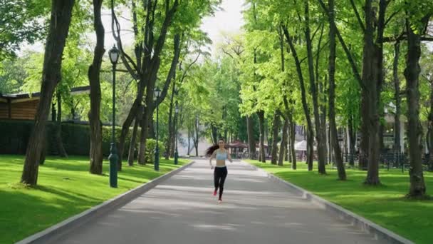 Mujer con formas curvas trotando en el parque — Vídeo de stock