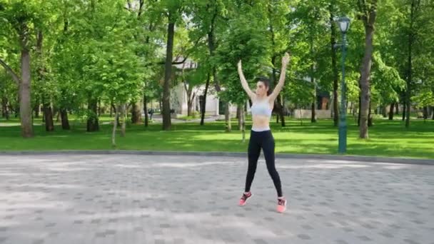 Female athlete jumping in park — Stock Video