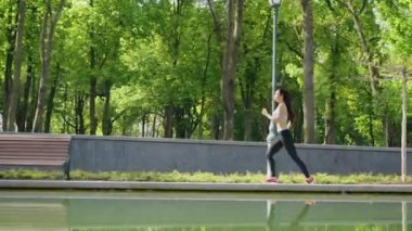 Park gölünde koşan zinde bir kadın.