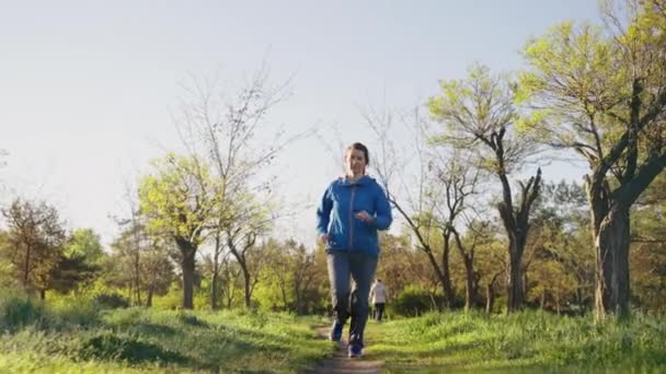 Femme jogging dans le parc le matin — Video