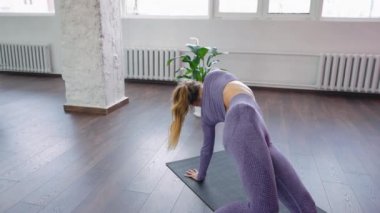 Sınıfta yoga yapan kadın Patita Tarasana 'yı oynuyor.