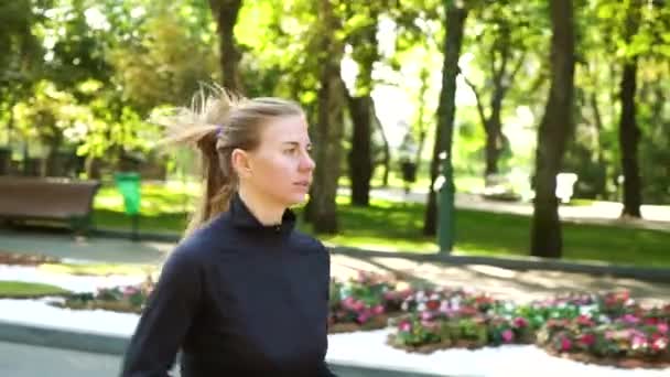 Femme blonde jogging dans un parc ensoleillé — Video