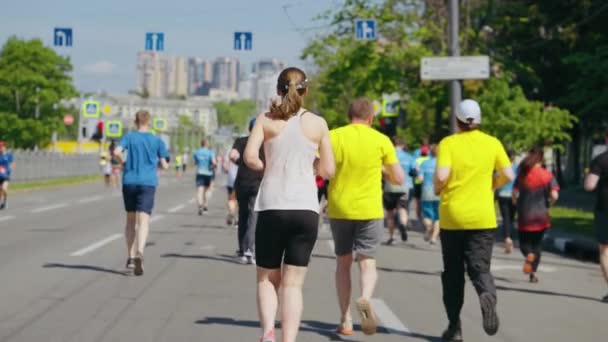 Biegacze maratońscy w zwolnionym tempie na drodze miejskiej — Wideo stockowe