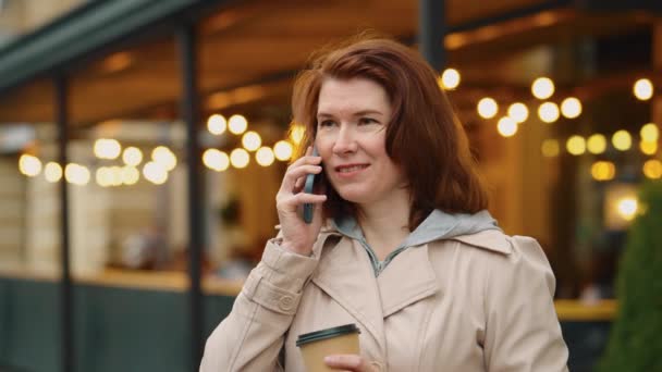Veselá žena mluví po telefonu a pije kávu — Stock video