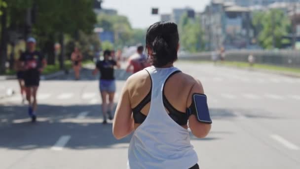 Slow motion woman with smartphone running race — Stok Video