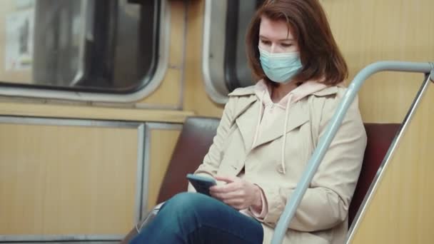 Женщина путешествует в метро и читает сообщения по телефону — стоковое видео