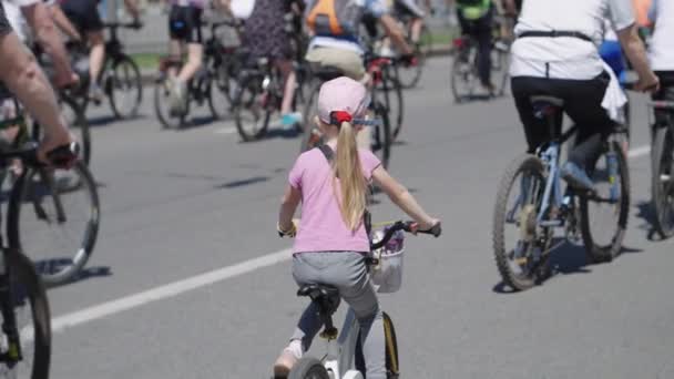 Маленькая девочка на велосипеде на уличной гонке — стоковое видео