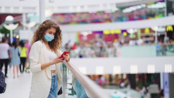 Kvinna pratar i telefon i köpcentret under en pandemi — Stockvideo
