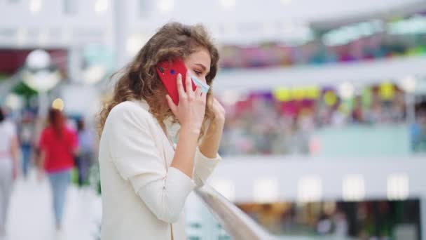 Alışveriş merkezinde maskeli bir kadın telefonda konuşuyor. — Stok video