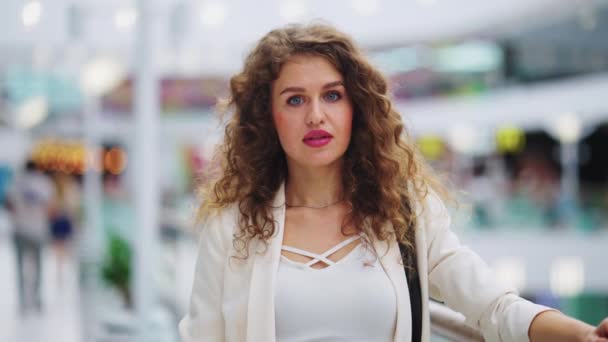 Красива жінка дивиться на камеру в торговому центрі — стокове відео