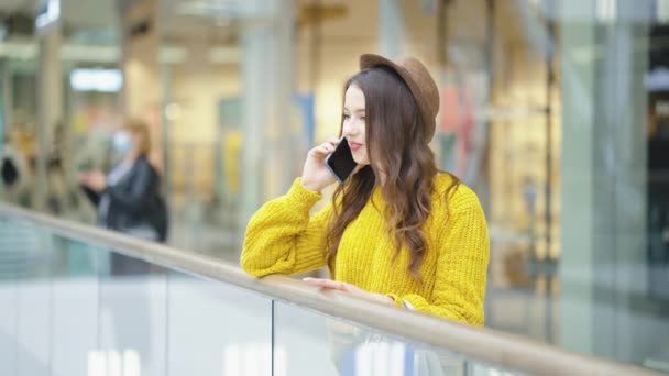 Femme heureuse parlant au téléphone dans le centre commercial — Video